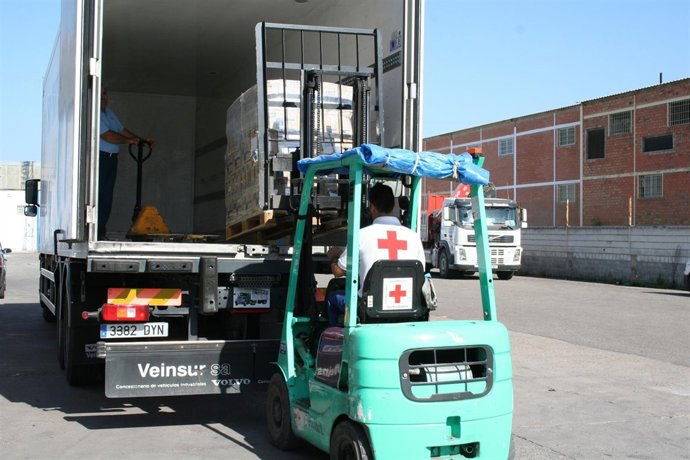 Un Operario De Cruz Roja Carga Un Palé Con Alimentos