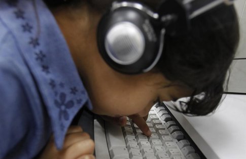 Una Niña Con Unos Cascos Juega Con Un Teclado De Ordenador
