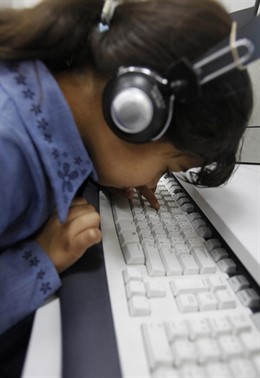Una Niña Con Unos Cascos Juega Con Un Teclado De Ordenador