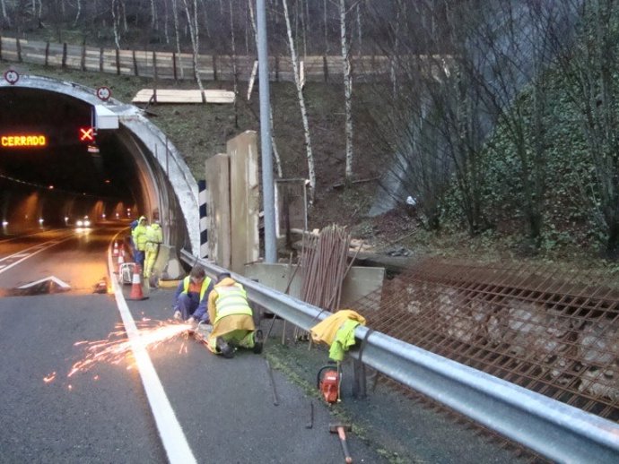 Personal Trabajando En La Instalación De Barreras En El Talud Afectado.