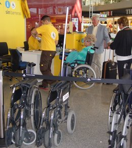Personal Atiende A Una Persona En El Punto De Movilidad Reducida Del Aeropuerto