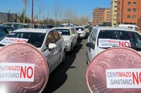 Más de 30 taxis se concentran en las Cortes contra el "centimazo"