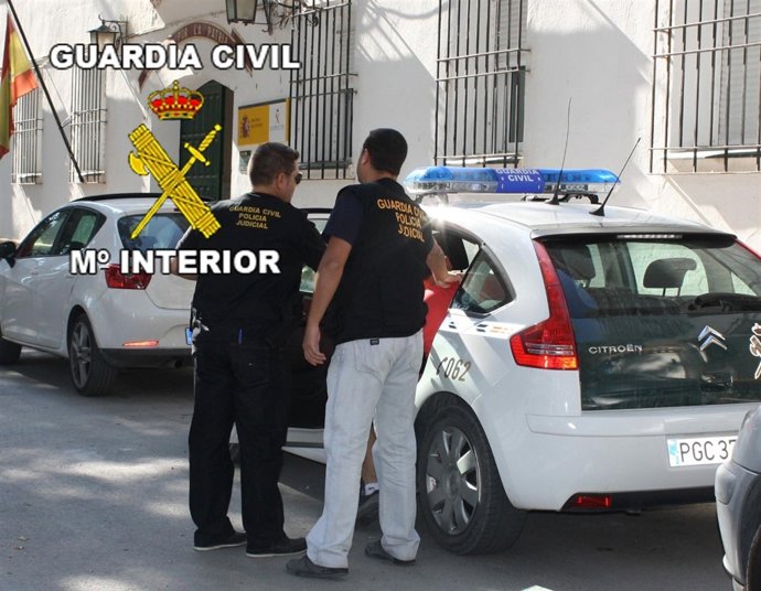 Los Agentes Introducen En El Vehículo Policial A Uno De Los Detenidos