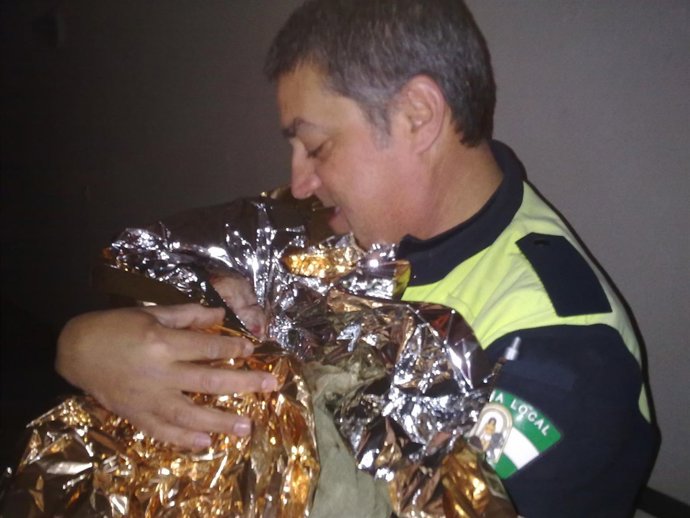 Uno De Los Agentes Presta Atención Al Recién Nacido.