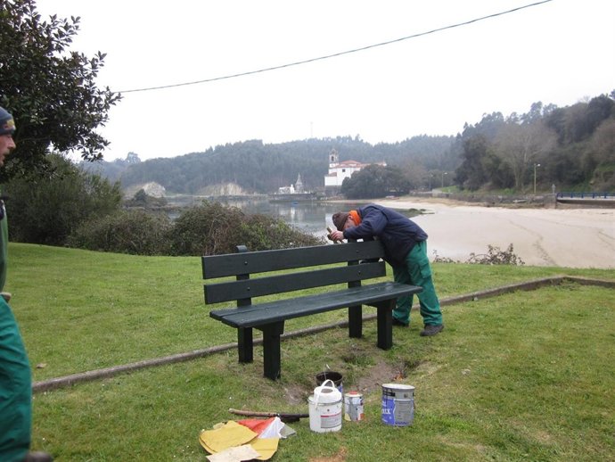 Un Operario Restaura Un Banco En Llanes