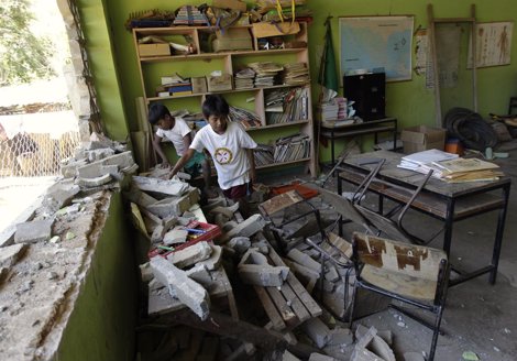 Children Stand Next To Debris Inside Their Classroom At Francisco Larrayo's Scho