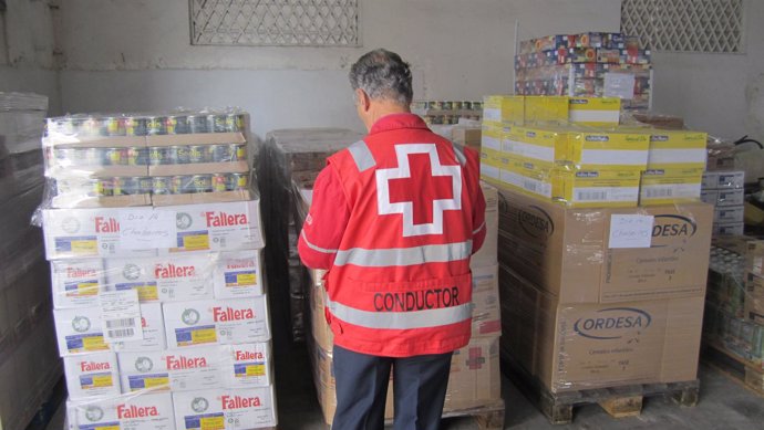 Un Miembro De Cruz Roja Con Productos Alimenticios Recogidos.