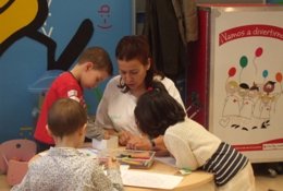 Niños Trabajando En El Aula Infantil Con Una De Las Profesoras
