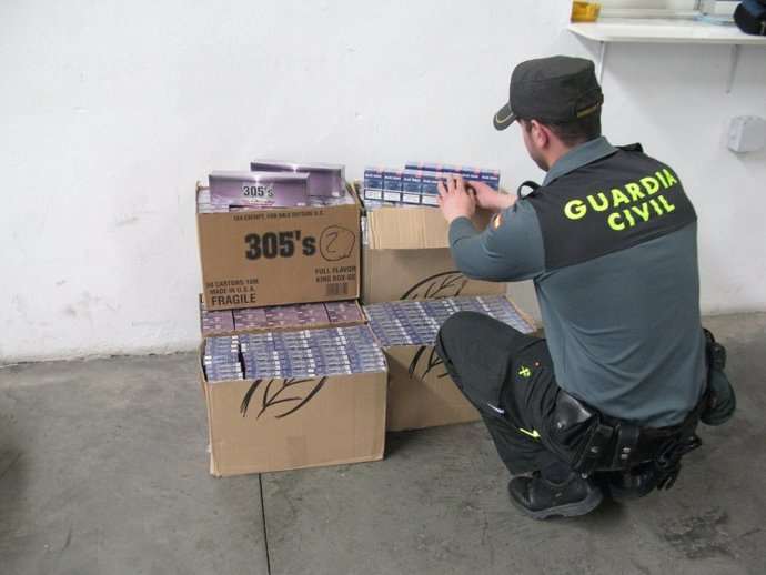 Agente De La Guardia Civil Con Las Cajetillas De Tabaco Incautadas