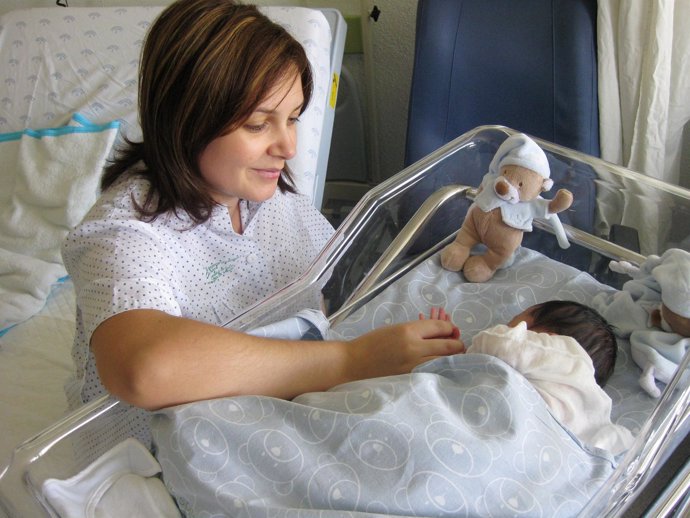 Una Madre Cuida A Su Bebé En La Cuna De Un Hospital