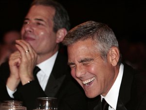 El actor George Clooney riéndose a carcajadas en una cena
