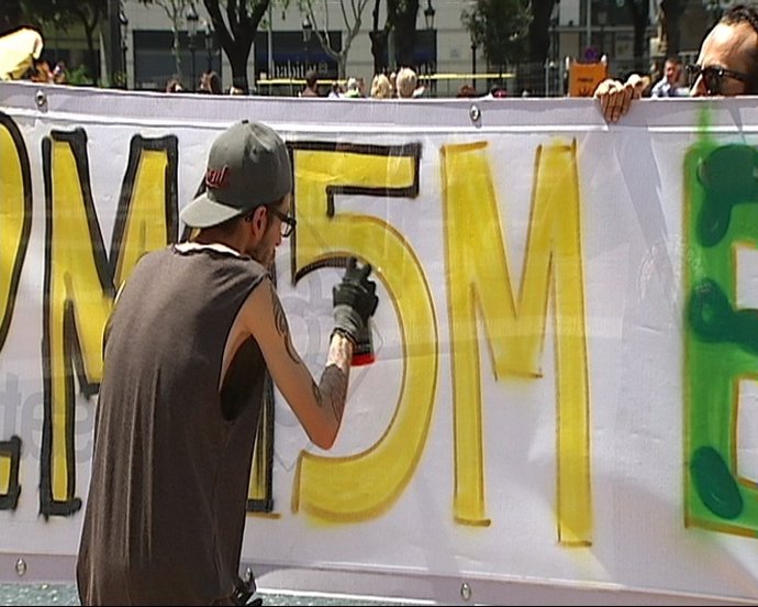 Un 'Indignado' Pinta La Pancarta De La Manifestación Del 15M De Barcelona
