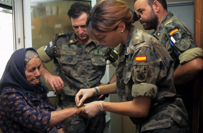 Militar Española Proporcionando Asistencia Sanitara A Una Anciana