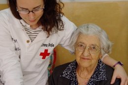 Un Voluntario De La Cruz Roja Ayuda A Una Anciana