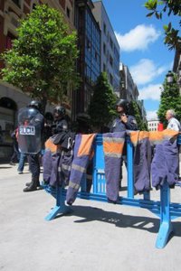 Los mineros se quitan la ropa de trabajo en la sentada ante la sede del PP de Asturias