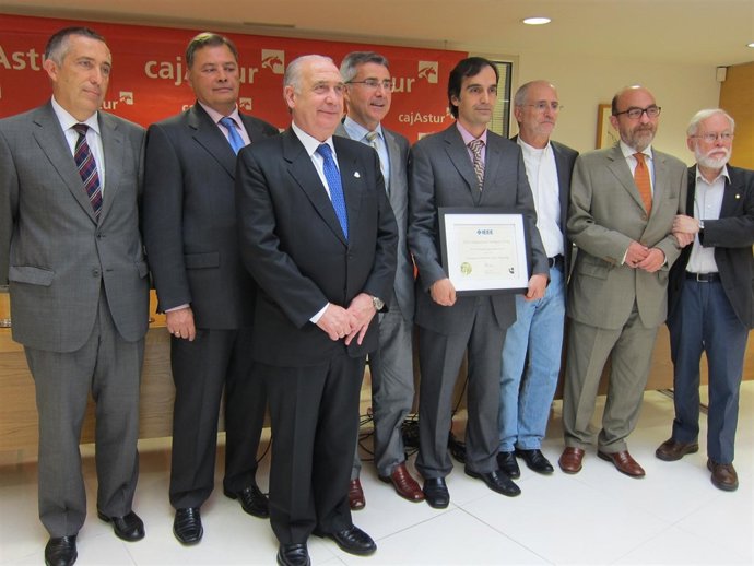 Magdalena, En El Centro, Sostiene El Diploma Del Galardón.
