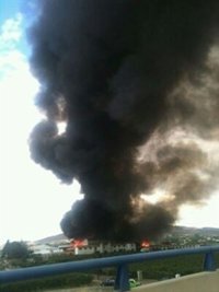 Bomberos trabajan en las labores de extinción de un incendio acaecido en una empresa de la carretera Soria