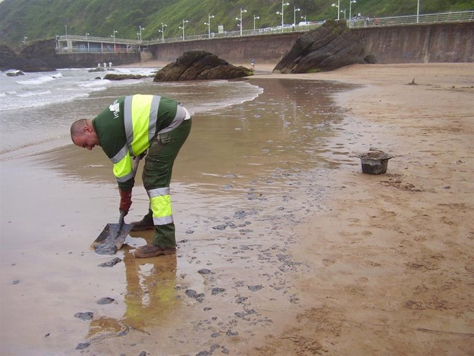 Un Operario Recoge Fuel Procedente Del Vertido En La Playa De Candás.