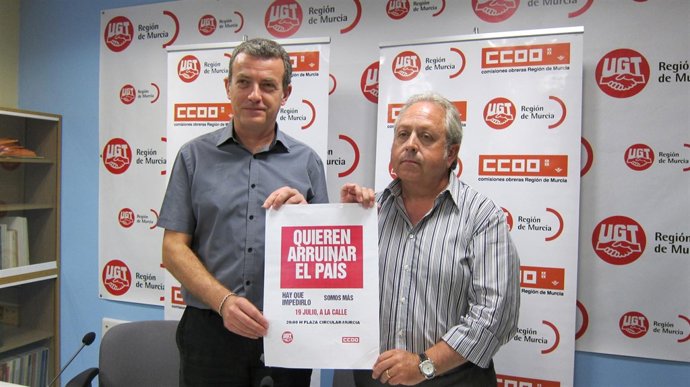 Daniel Bueno y Antonio Jiménez muestran el eslogan de la manifestación del 19 de