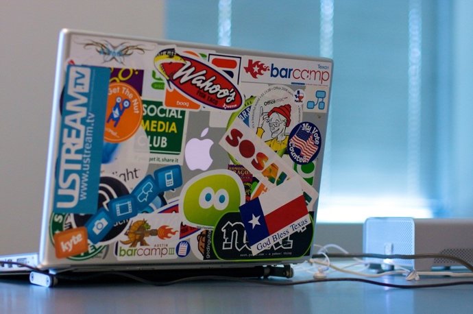 Ordenador portátil Mackbook con pegatinas stickers publicidad
