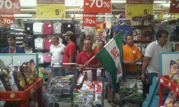 Dirigentes del SAT con carros de comida para llevarlos a un banco de alimentos