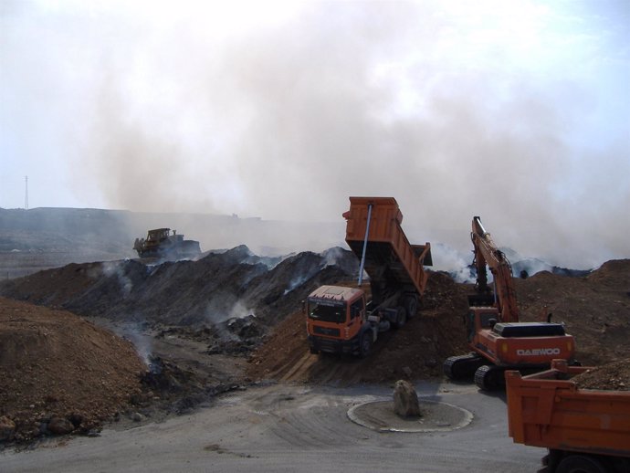 Un Camión Echa Tierra Sobre Las Pilas De Residuos Para Sofocar La Combustión