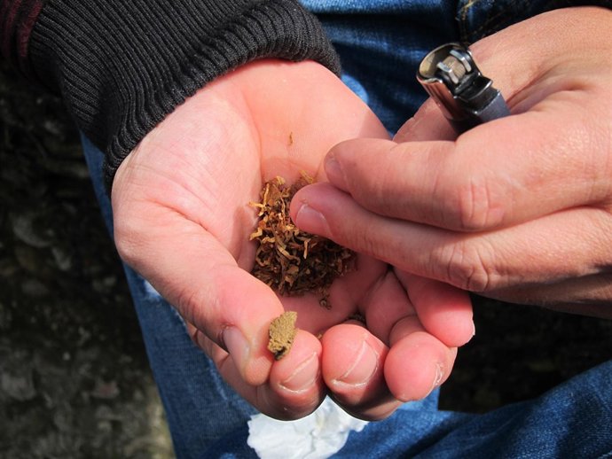 Un joven elaborando un porro de hachís