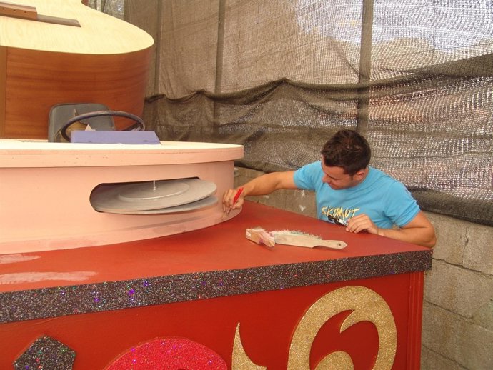 Joven pintando una de las carrozas