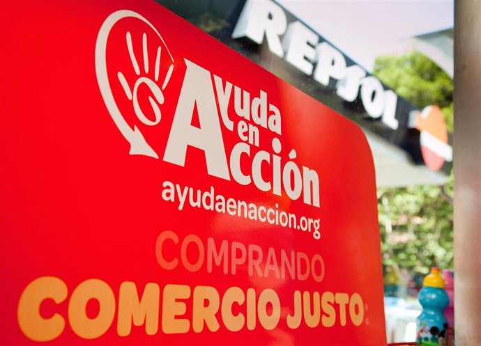 Un cartel anuncia la venta de productos de comercio justo en una gasolinera