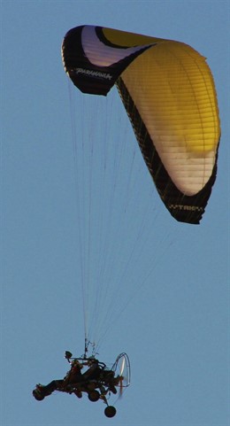 Un piloto de Paramotor en pleno vuelo.