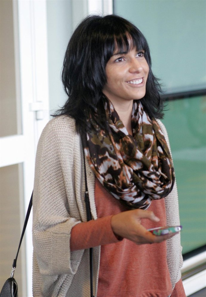 Raquel del Rosario muy sonriente móvil en mano 