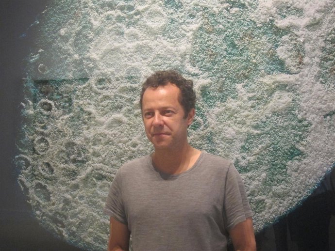 El artista Vik Muniz, junto a una de sus obras