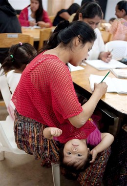 Alumna en clases de alfabetización con su hija