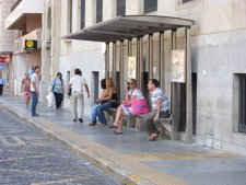 Usuarios esperan el autobús en Huelva. 