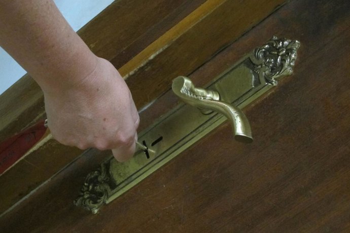 Una mujer abre la puerta de su vivienda