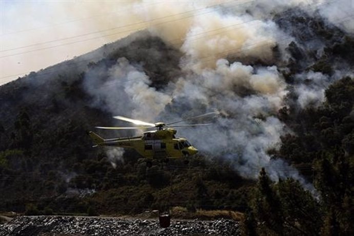 Un helicóptero participa en la extinción del incendio de O Barco