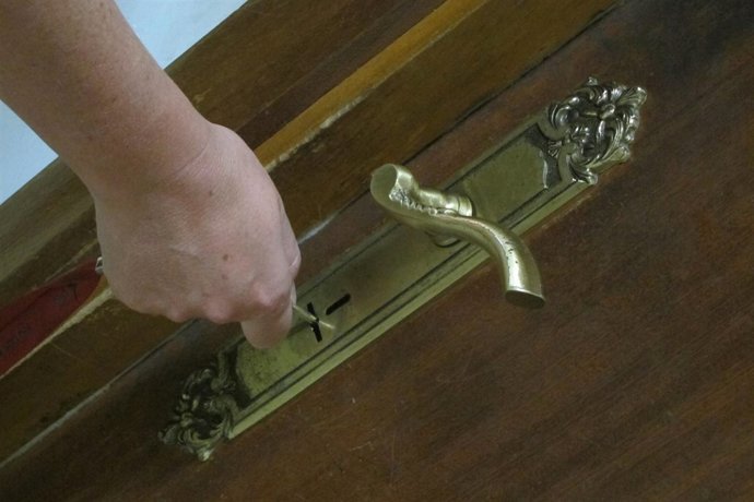 Una mujer abre la puerta de su vivienda