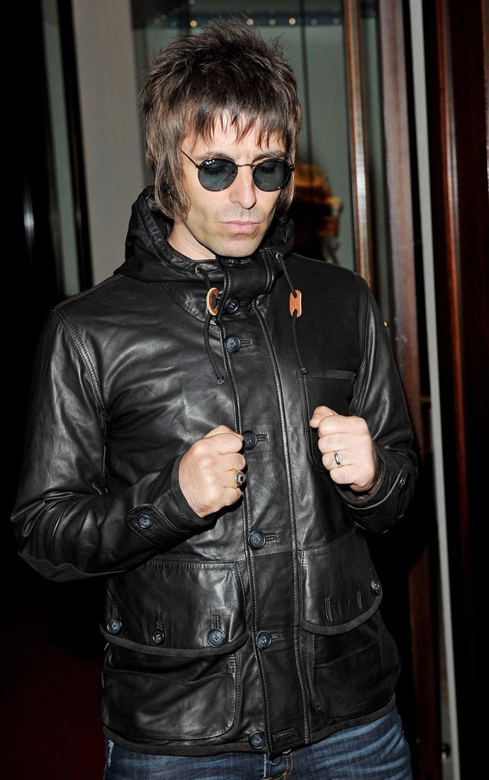 Liam Gallagher con chaqueta negra de cuero y gafas redondas de sol 