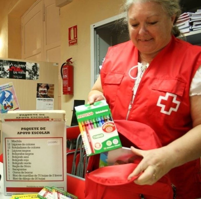 Una Voluntaria Muestra El Paquete De Apoyo Escolar De Cruz Roja