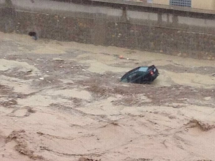 Un coche arrastrado por la riada en una rambla