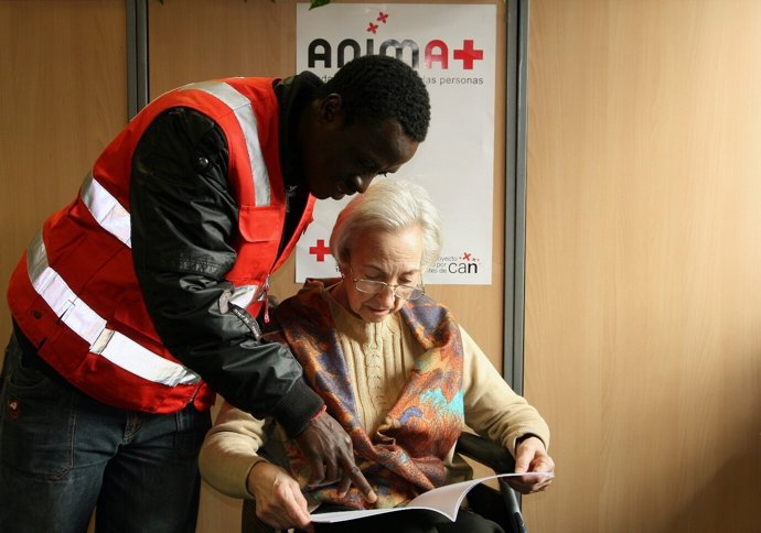Un miembro de Cruz Roja atiende a una persona mayor.