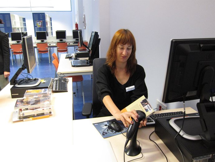 Una empleada de la Biblioteca escanea un libro