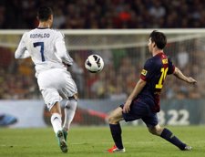 Cristiano y Messi luchan por un balón