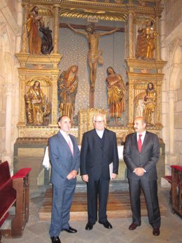 Ramón Álvarez, Eduardo Prieto y José Manuel Fernández Corral ante el retablo