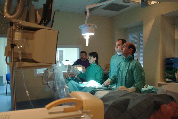 Médicos cirujanos observan las constantes vitales de un paciente