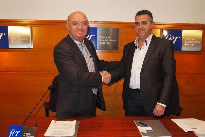 Los responsables de FER y Cáritas, tras firmar el convenio