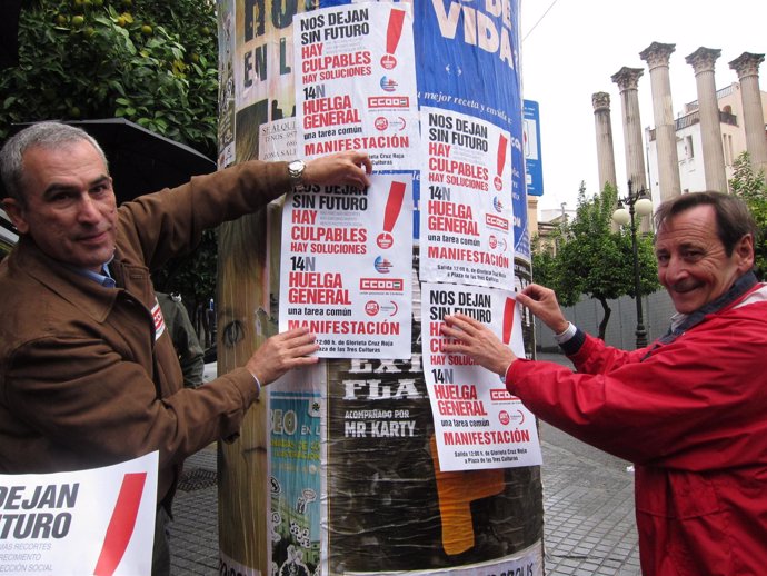 Sindicalistas pegando carteles por la huelga general del 14N