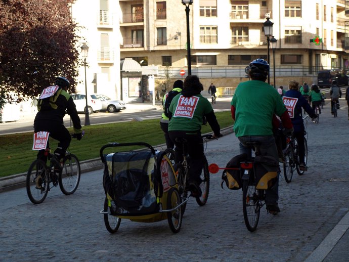 Ciudadanos en bicicleta por Salamanca con carteles de apoyo a la huelga general 