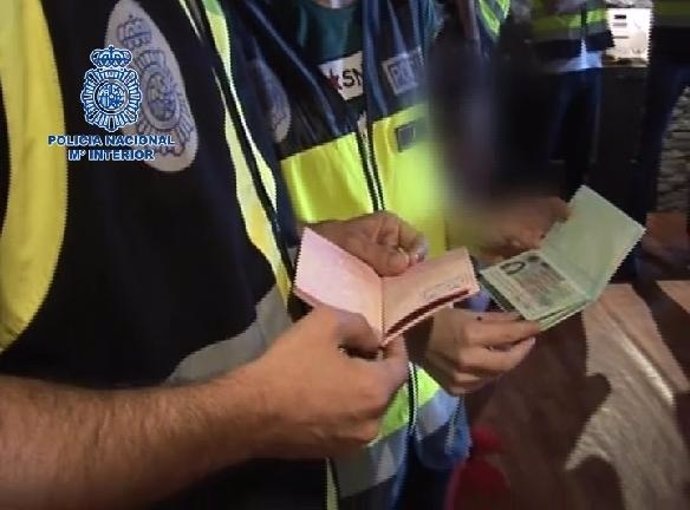 Policías inspeccionando pasaportes falsos