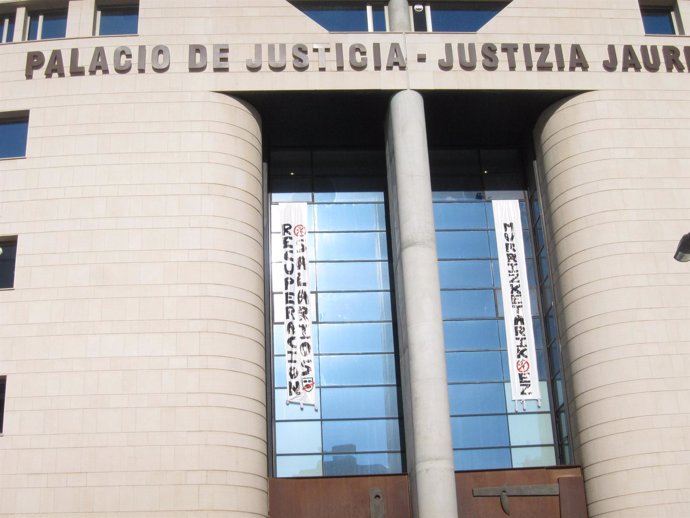 Imagen del Palacio de Justicia con dos pancartas contra los recortes.